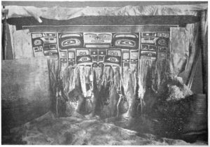 Een oude foto van een Chilkat in de maak. Let op de gewichten aan de losse kettingdraden.